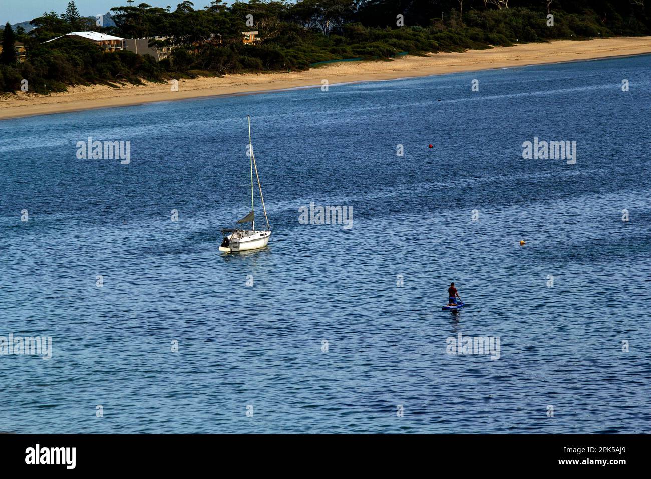 Touriste profitant d'une expérience de paddleboard à Shoal Bay Beach, Port Stephens, Mid North Coast, Nouvelle-Galles du Sud, Australie. Shoal Bay est le plus eas Banque D'Images