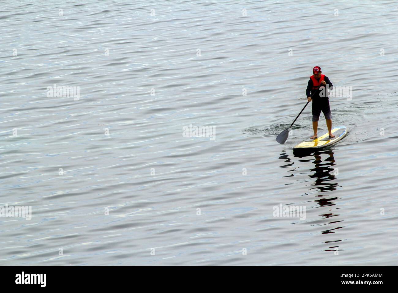 Touriste profitant d'une expérience de paddleboard à Shoal Bay Beach, Port Stephens, Mid North Coast, Nouvelle-Galles du Sud, Australie. Shoal Bay est le plus eas Banque D'Images