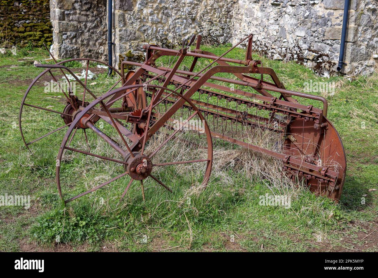 Un vieux matériel agricole rouillé et désutilisé trouvé à l'extérieur d'une grange à Malhamdale Banque D'Images