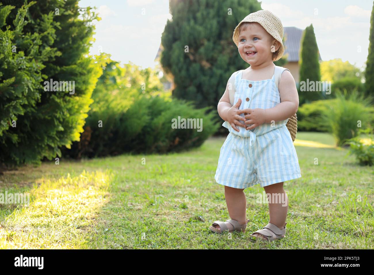 Jolie petite fille portant des vêtements élégants à l'extérieur par beau temps. Espace pour le texte Banque D'Images