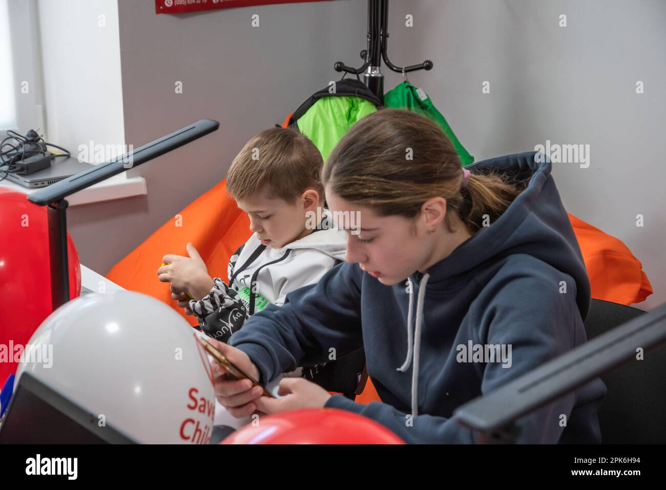 Les enfants s'assoient à une table avec des ordinateurs portables et des tablettes dans une salle de classe. Ouverture officielle du Digital Learning Centre à l'Ecole supérieure des technologies informatiques et de la construction de Lviv, qui a été fondée par l'organisation humanitaire internationale Save the Children avec le soutien du Ministère norvégien des affaires étrangères. L'objectif du Centre d'apprentissage numérique est l'accès sécuritaire à l'enseignement à distance pour les enfants âgés de 6 à 17 ans, l'accès à l'éducation non formelle interactive. Le centre d'apprentissage numérique assure l'accès continu des enfants à l'éducation et à la socialisation de l'enseignement interne Banque D'Images