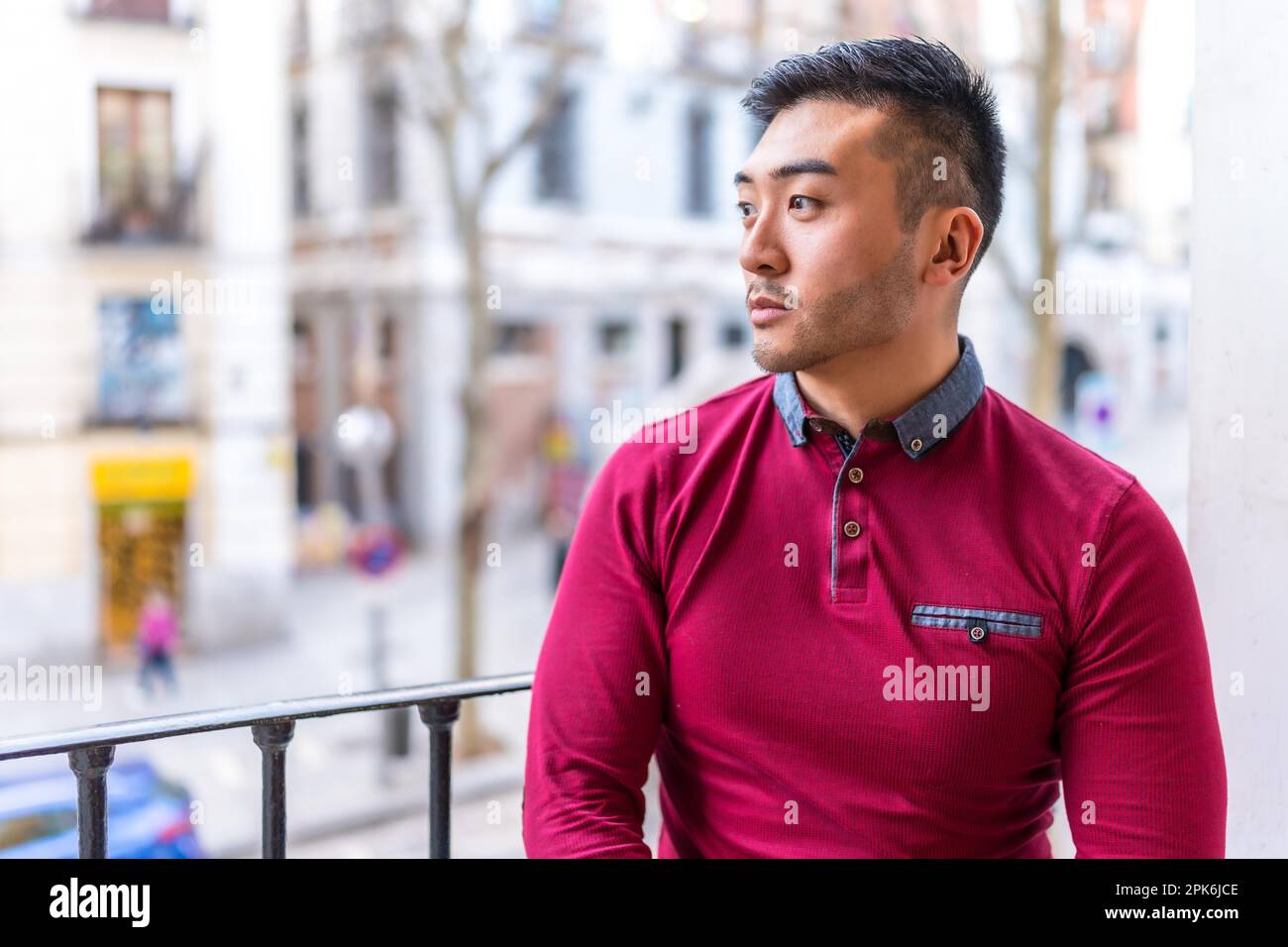 Portrait d'un jeune Chinois sur un balcon à la maison, situation quotidienne, appartement Banque D'Images