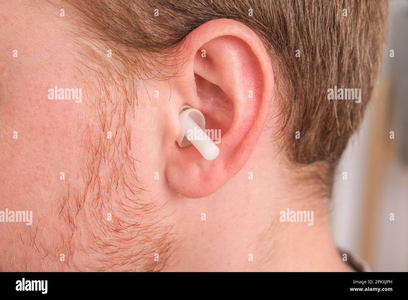 Un homme insère des bouchons d'oreilles dans ses oreilles afin de ne pas  entendre de bruit parasite, de musique, de ronflement. Bouchons d'oreilles  en silicone pour dormir Photo Stock - Alamy