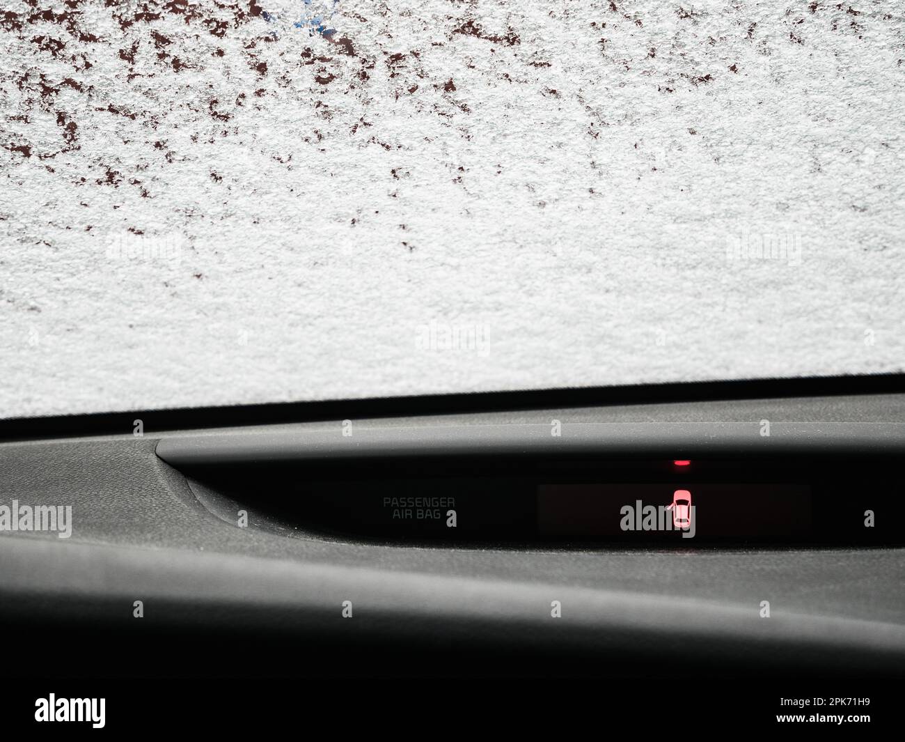 Un intérieur d'automobile élégant, avec une porte ouverte révélant un panneau et une fenêtre couverts de neige à l'extérieur. Banque D'Images