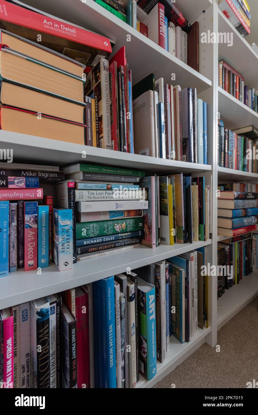 Bibliothèque en bois blanc bien rempli dans une bibliothèque à la maison, Royaume-Uni Banque D'Images