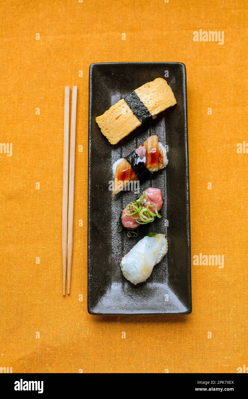 Plateau de sushis, sélection de poissons crus et d'en-cas de riz avec baguettes. Banque D'Images