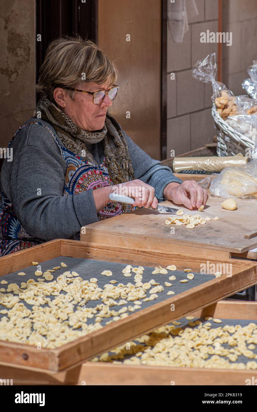 Mains froissées d'une femme âgée préparant une orecchiette ou orecchietta fraîche, faite avec du blé dur et de l'eau, pâtes faites à la main typiques de Puglia Banque D'Images