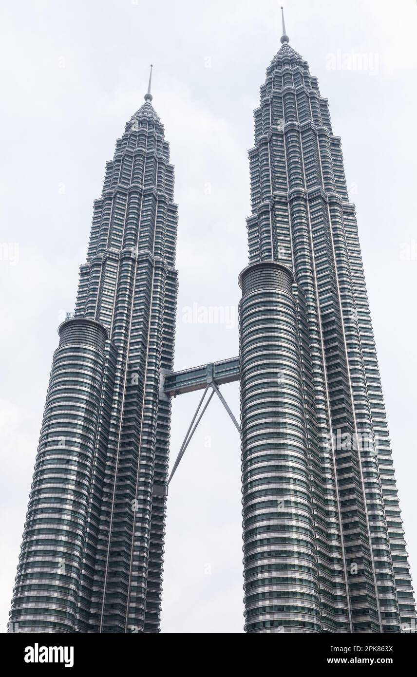 Kuala Lumpur, Malaisie - 25 novembre 2019 : l'extérieur des tours jumelles Petronas est sous un ciel nuageux et lumineux. Photo verticale Banque D'Images