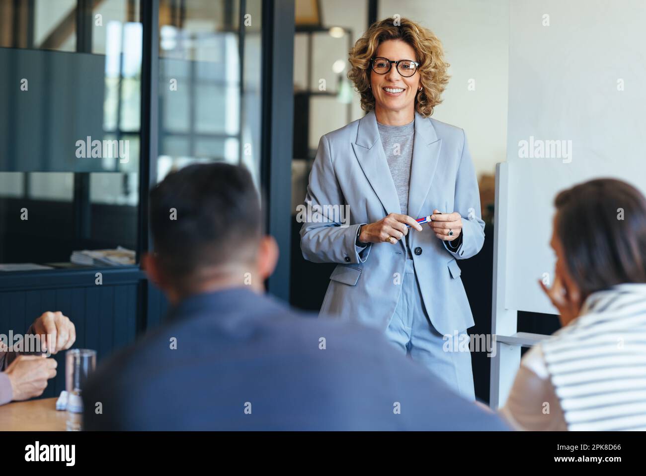 Femme d'affaires mature ayant une discussion avec son équipe. Femme dirigeant une réunion dans un bureau. femme d'affaires présentant ses idées dans un bureau. Groupe Banque D'Images