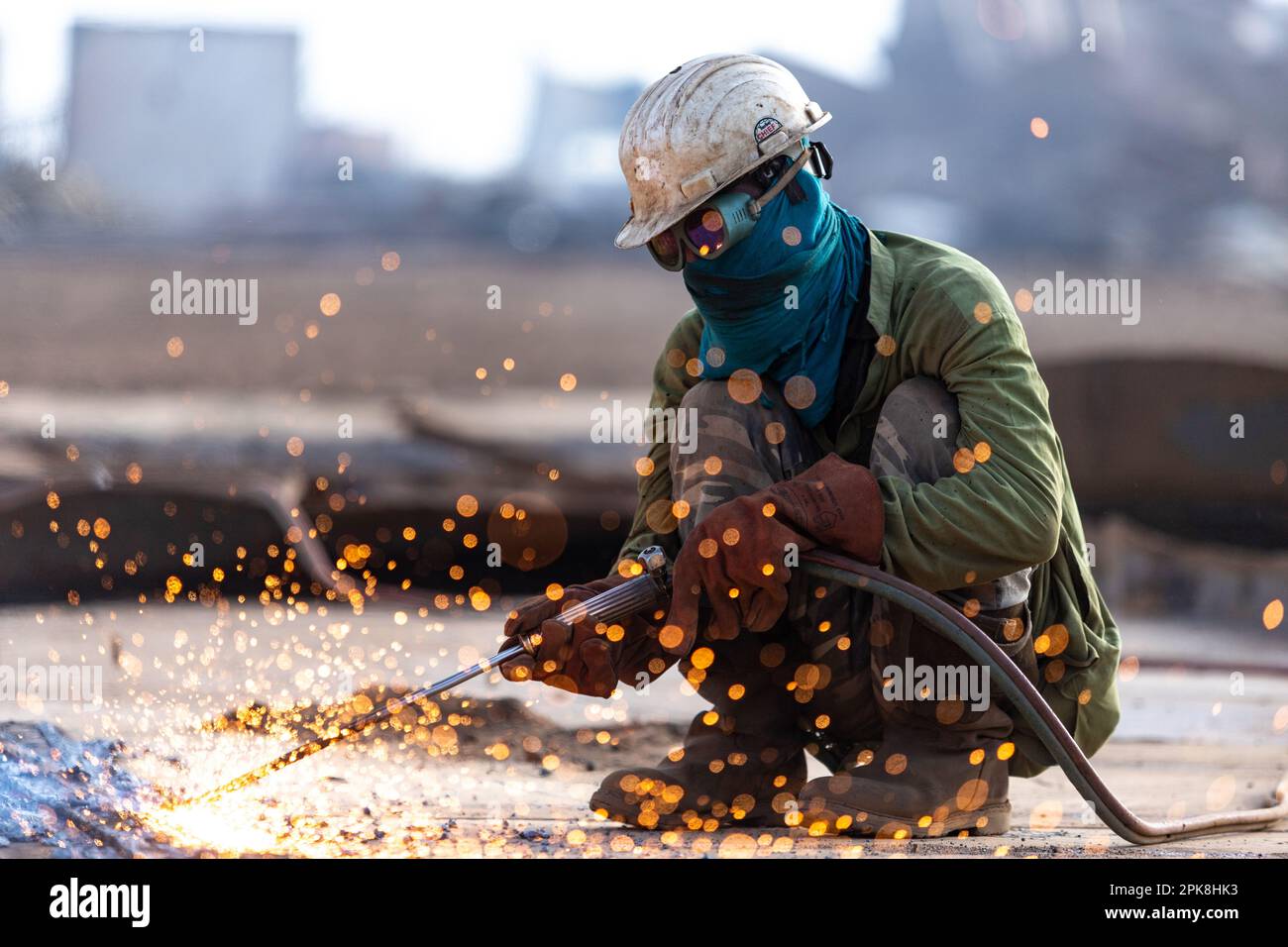 Gadani Pakistan août 2021, un travailleur portant un casque de sécurité jaune coupant une tôle avec un arc de soudage au chantier de démolition de navire de Gadani Banque D'Images