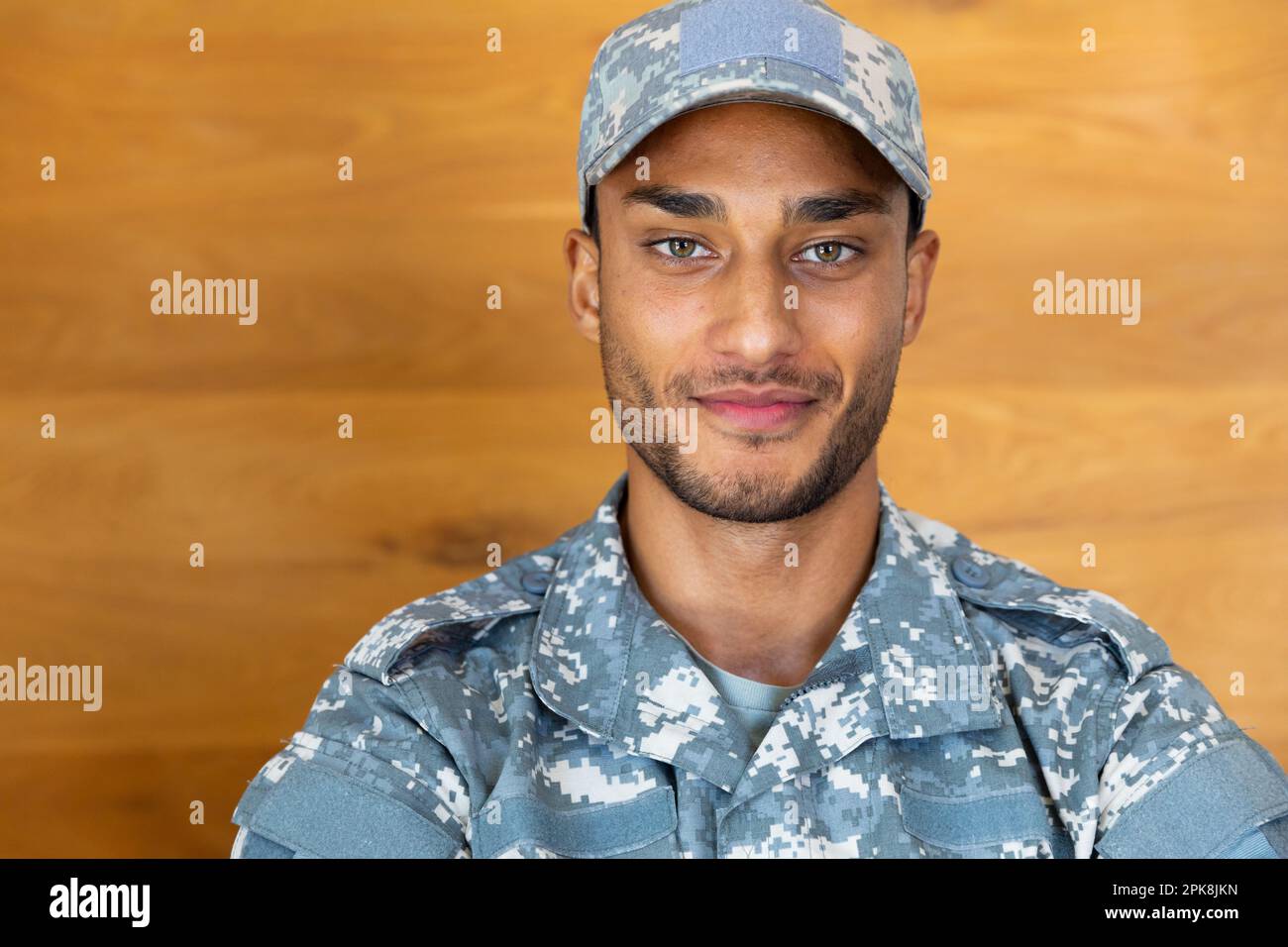 Portrait d'un homme biracial heureux, portant un uniforme militaire et une casquette, regardant l'appareil photo. Style de vie, service militaire et temps libre, sans modification. Banque D'Images