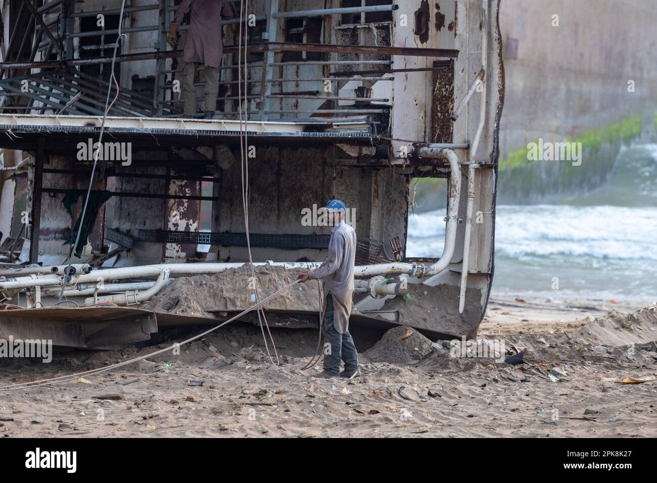 Gadani Pakistan le 2021 août, un travailleur portant un casque de sécurité rouge travaillant sur l'épave du navire à la cour de cassation du navire Gadani. Banque D'Images