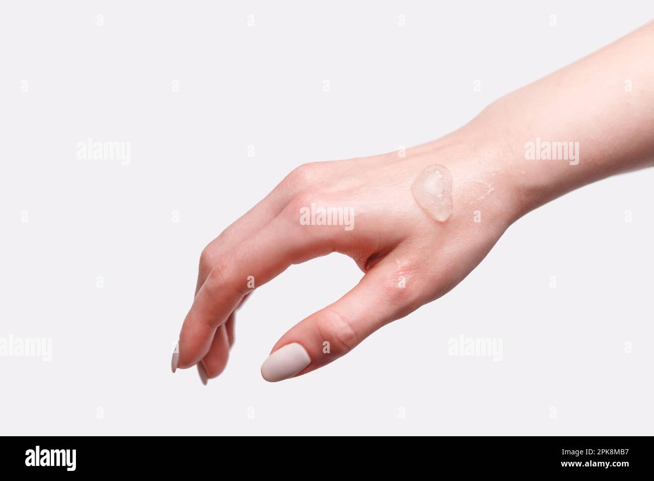 Femme dos de la main avec un échantillon de gel hydratant à l'oxygène, isolé sur blanc. Banque D'Images