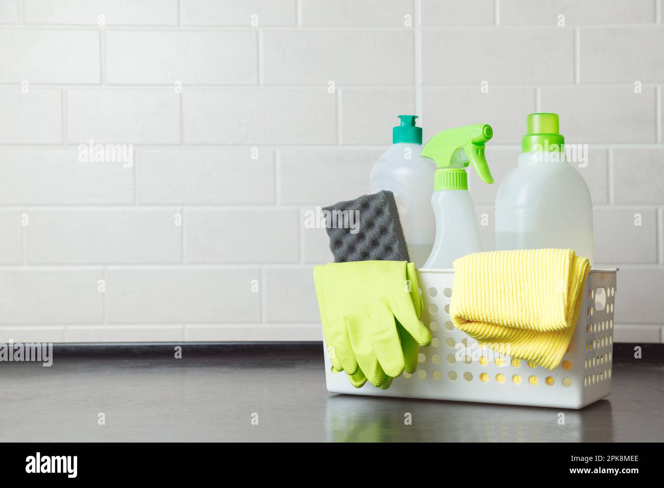 Panier avec détergents, gants et éponges sur la table de cuisine. Détergent vaisselle inoffensif. Détergent pour le lavage des sols. Produit chimique de nettoyage ménager Banque D'Images