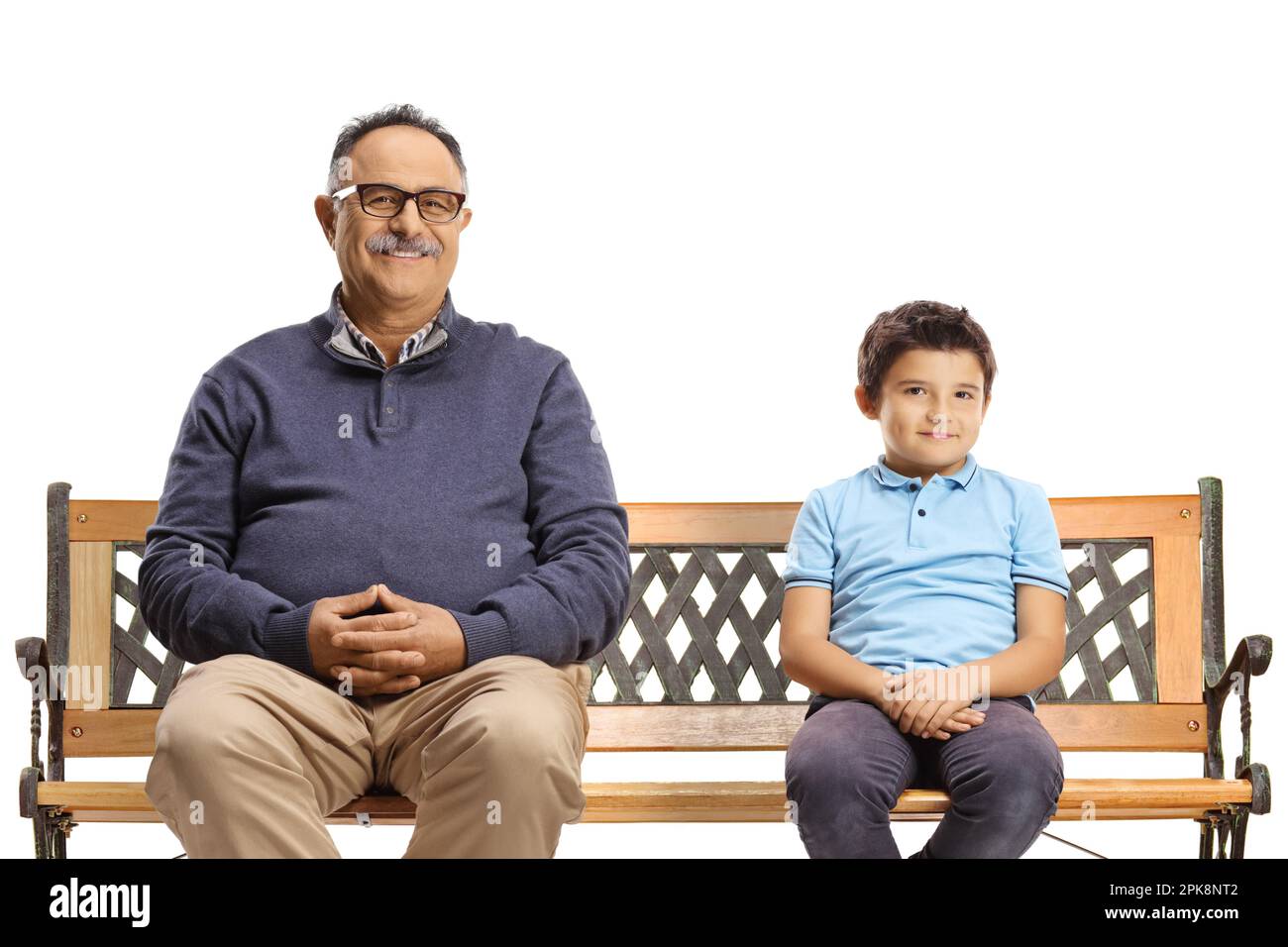 Joyeux homme mature et un garçon assis sur un banc et regardant la caméra isolée sur fond blanc Banque D'Images