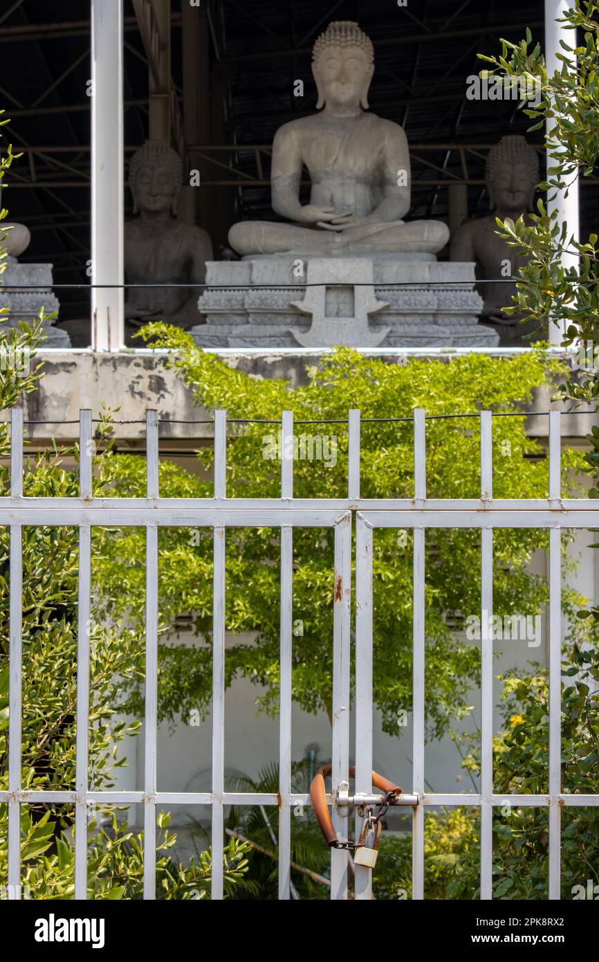 Une porte fermée devant un bâtiment avec des statues de Bouddha assis, Thaïlande Banque D'Images