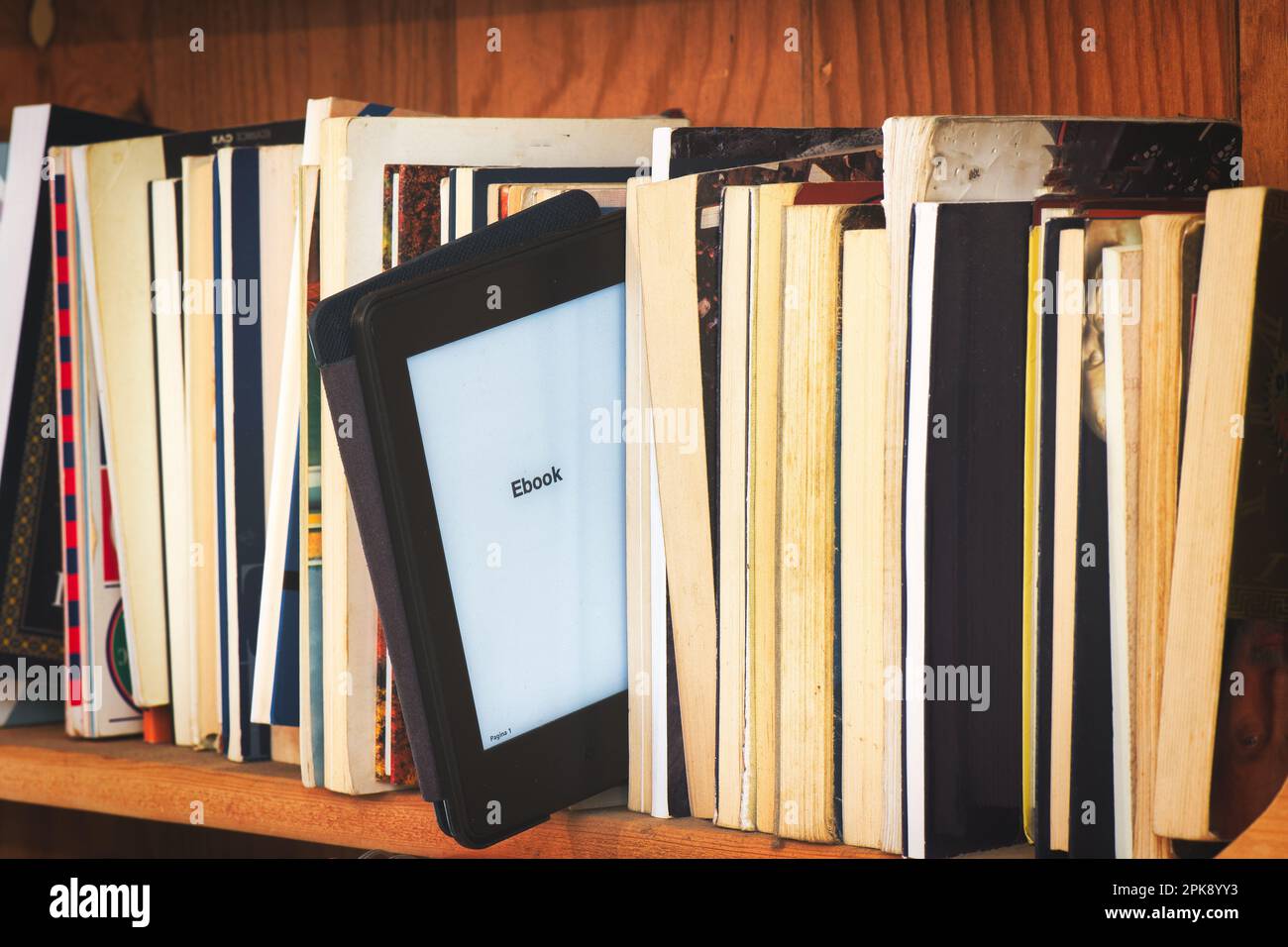 Bibliothèque en bois avec lecteur de livres électroniques au milieu des livres classiques Banque D'Images