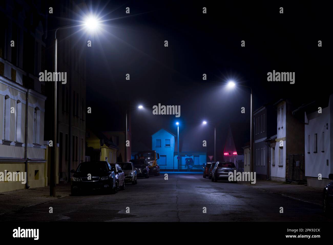La nuit dans la rue, peu de brouillard dans la lanterne, les voitures se garent sur le bord de la route Banque D'Images