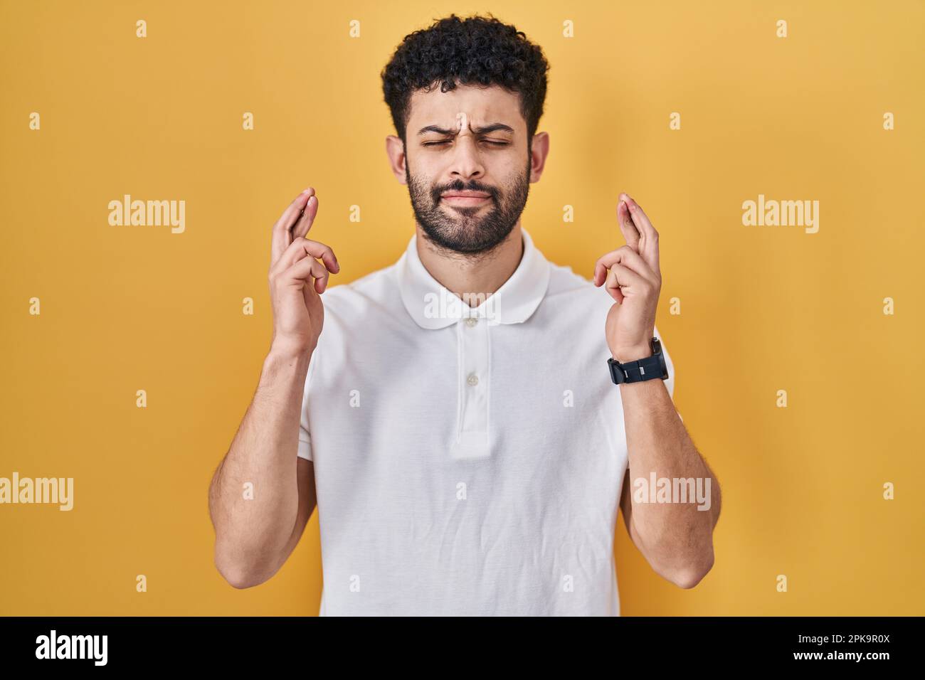 Lhomme arabe debout sur fond jaune gestant le doigt traversé sourire avec  espoir et les yeux fermés. chance et concept superstitieux Photo Stock -  Alamy