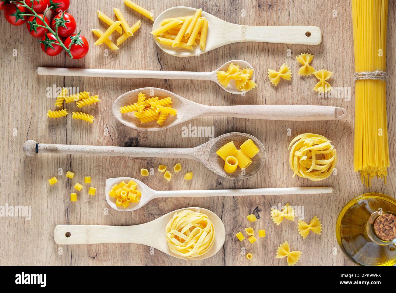 Diverses pâtes en cuillères, tomates et huile d'olive. Plan d'étapage avec vue de dessus Banque D'Images