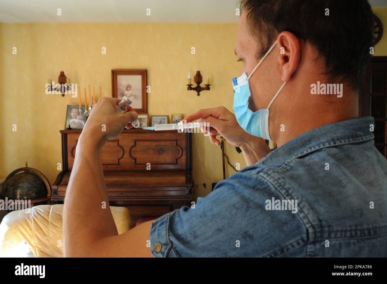 Une infirmière de pays libéral au domicile d'un patient pour une injection intramusculaire de ceftriaxone, antibiotiques antibactériens pour une infection urinaire. Banque D'Images