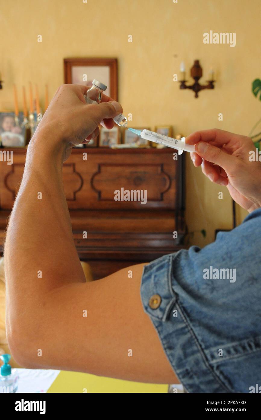 Une infirmière de pays libéral au domicile d'un patient pour une injection intramusculaire de ceftriaxone, antibiotiques antibactériens pour une infection urinaire. Banque D'Images