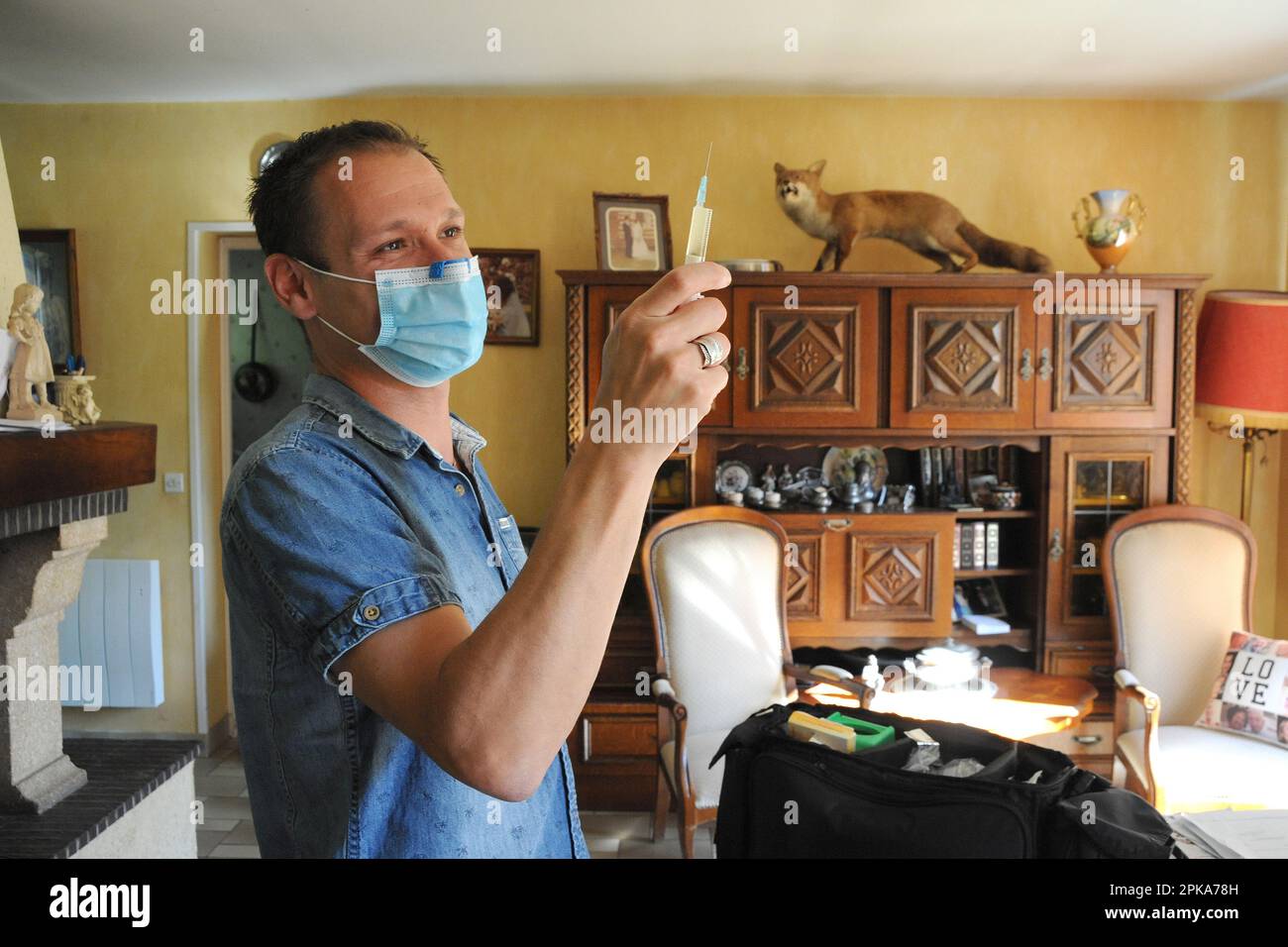 Une infirmière de pays libéral au domicile d'un patient pour une injection intramusculaire de ceftriaxone, antibiotiques antibactériens pour une infection urinaire. Banque D'Images