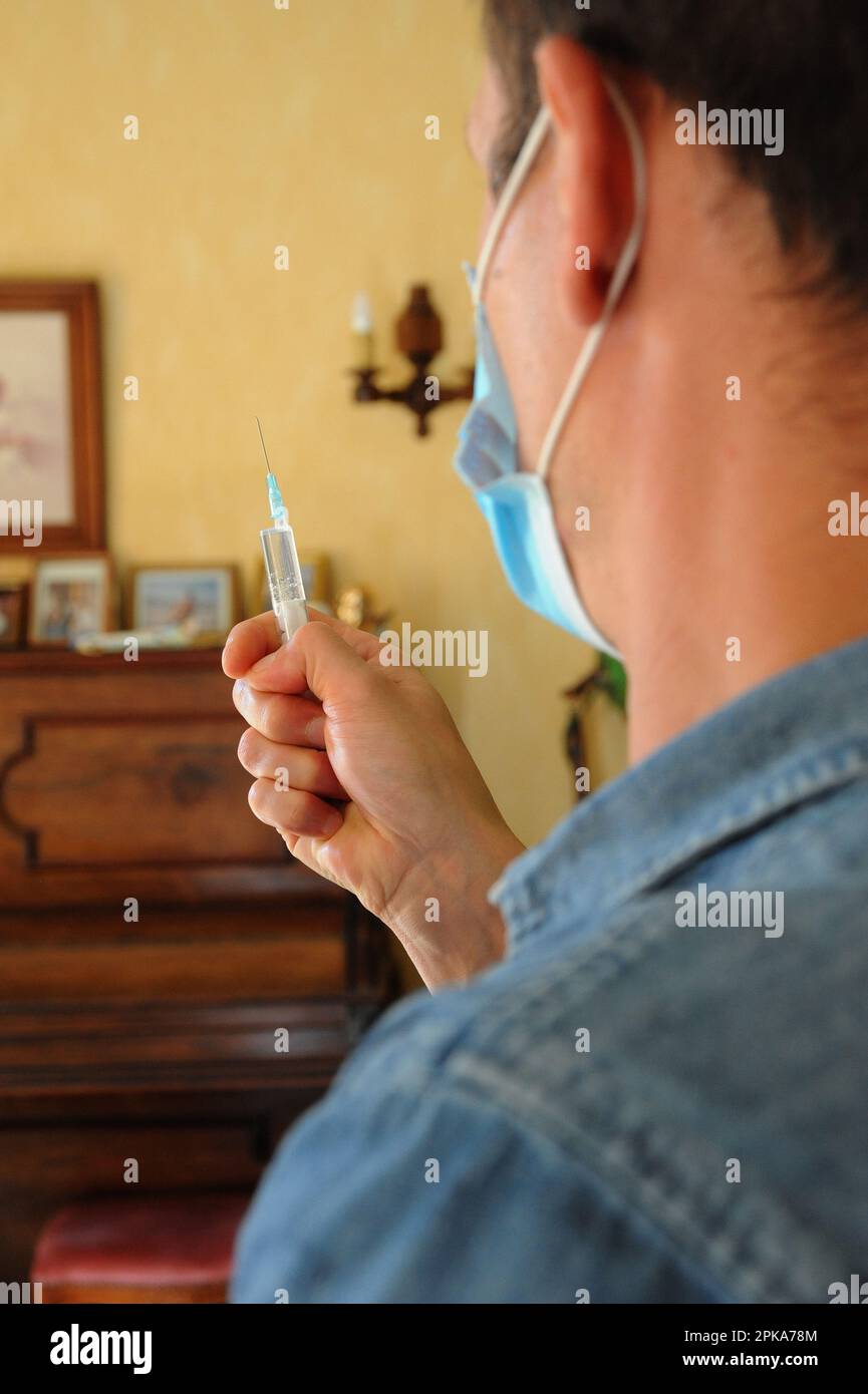 Une infirmière de pays libéral au domicile d'un patient pour une injection intramusculaire de ceftriaxone, antibiotiques antibactériens pour une infection urinaire. Banque D'Images