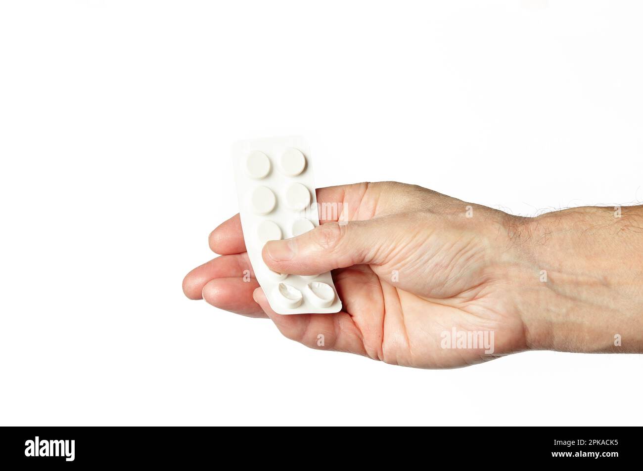Main d'homme tenant des pilules blanches dans la forme commune des comprimés isolés sur fond blanc. Main avec des pilules, gros plan Banque D'Images