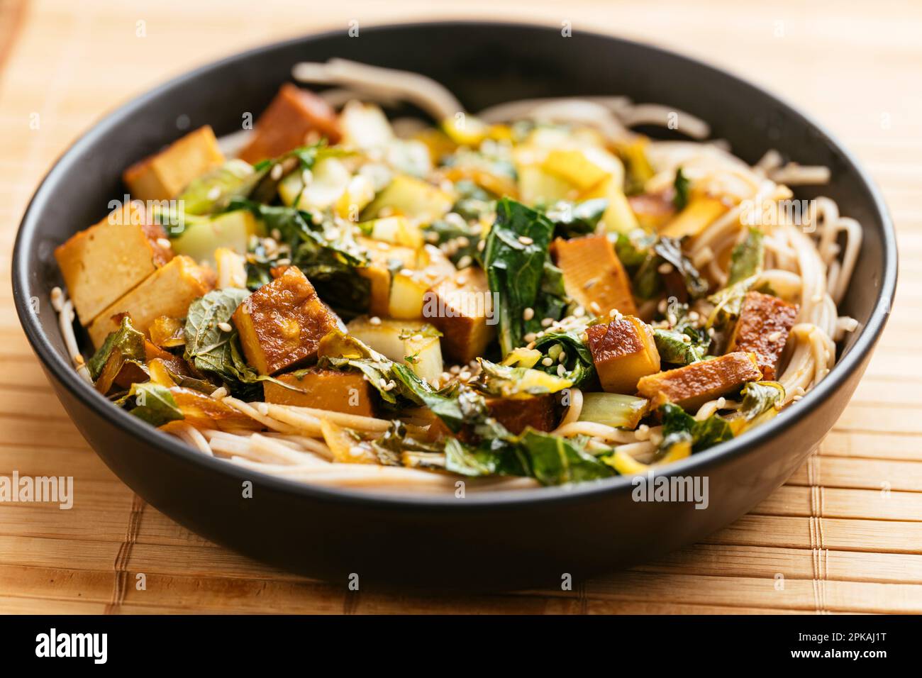 Bok Choi Stir-Fry avec tofu fumé sur des nouilles de sarrasin. Banque D'Images