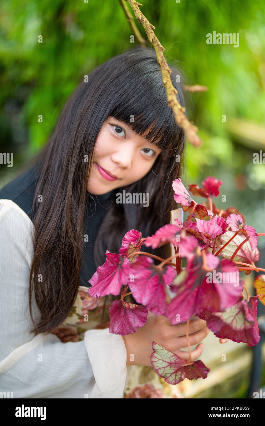 Jeune femme asiatique Shopping pour des plantes | Holding Potted Plant | Smiling Banque D'Images