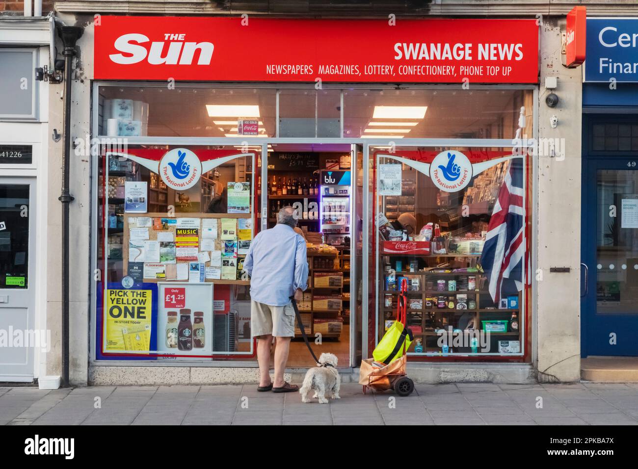 Angleterre, Dorset, île de Purbeck, Swanage, Homme et chien devant la boutique locale Banque D'Images
