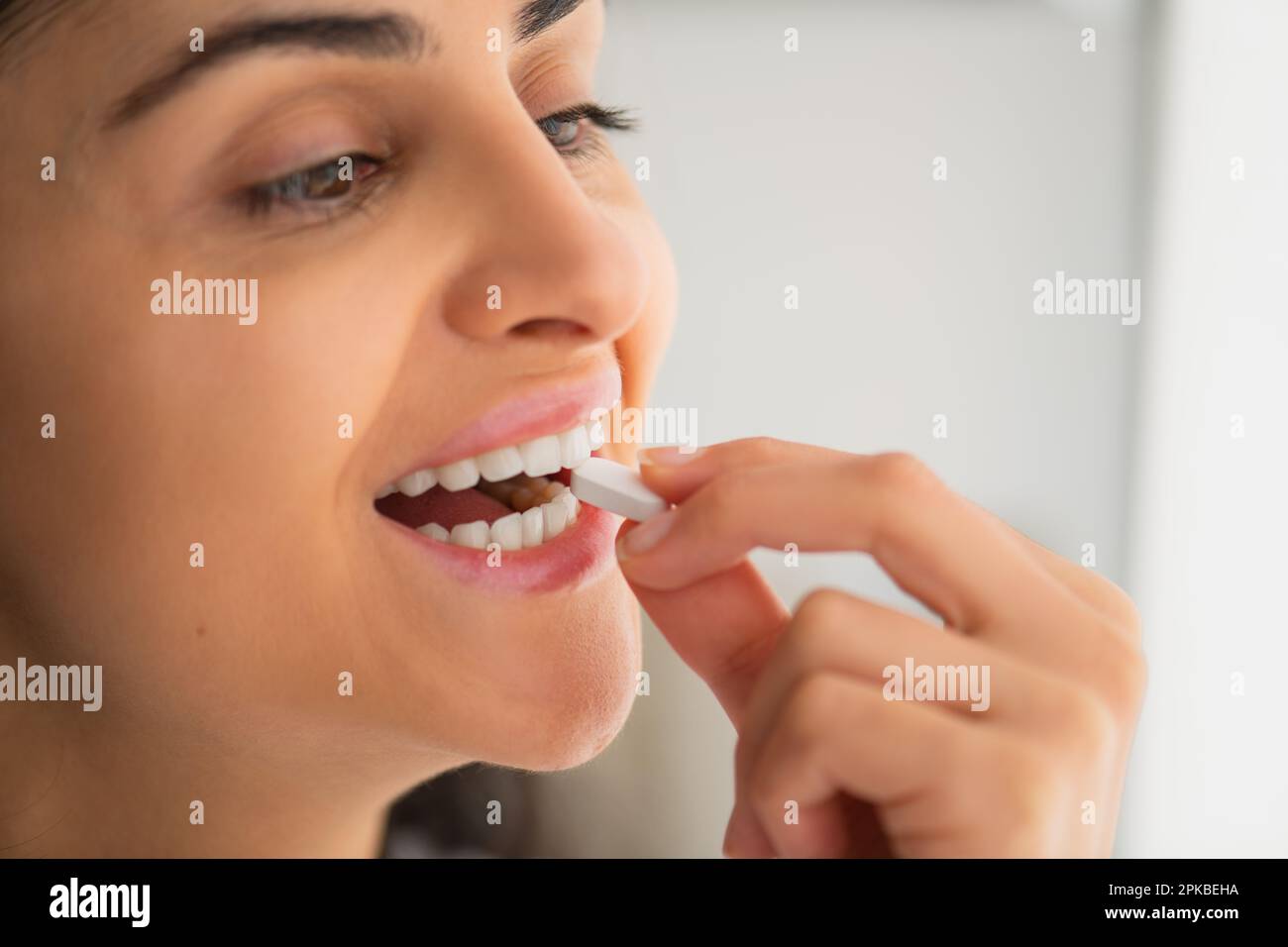 Multiracial jeune femme prêt pilule blanche de calcium avec un verre d'eau en main, mode de vie sain dans la prévention et le traitement des maladies Banque D'Images