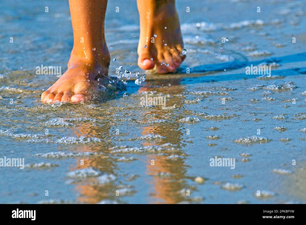 les pieds mouillés sur la mer propre le matin Banque D'Images