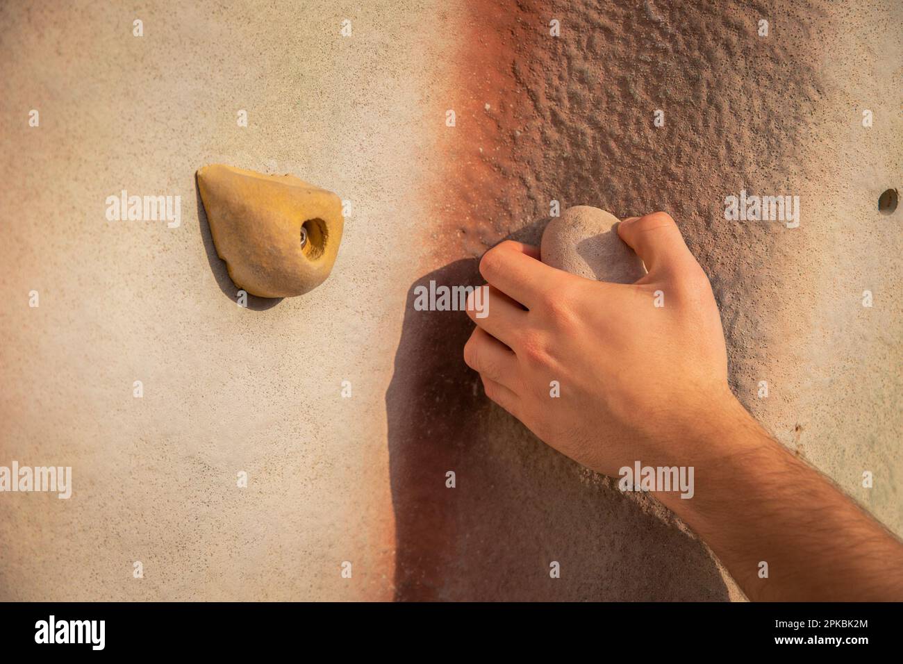Gros plan des mains d'un grimpeur qui saisit une poignée d'escalade Banque D'Images