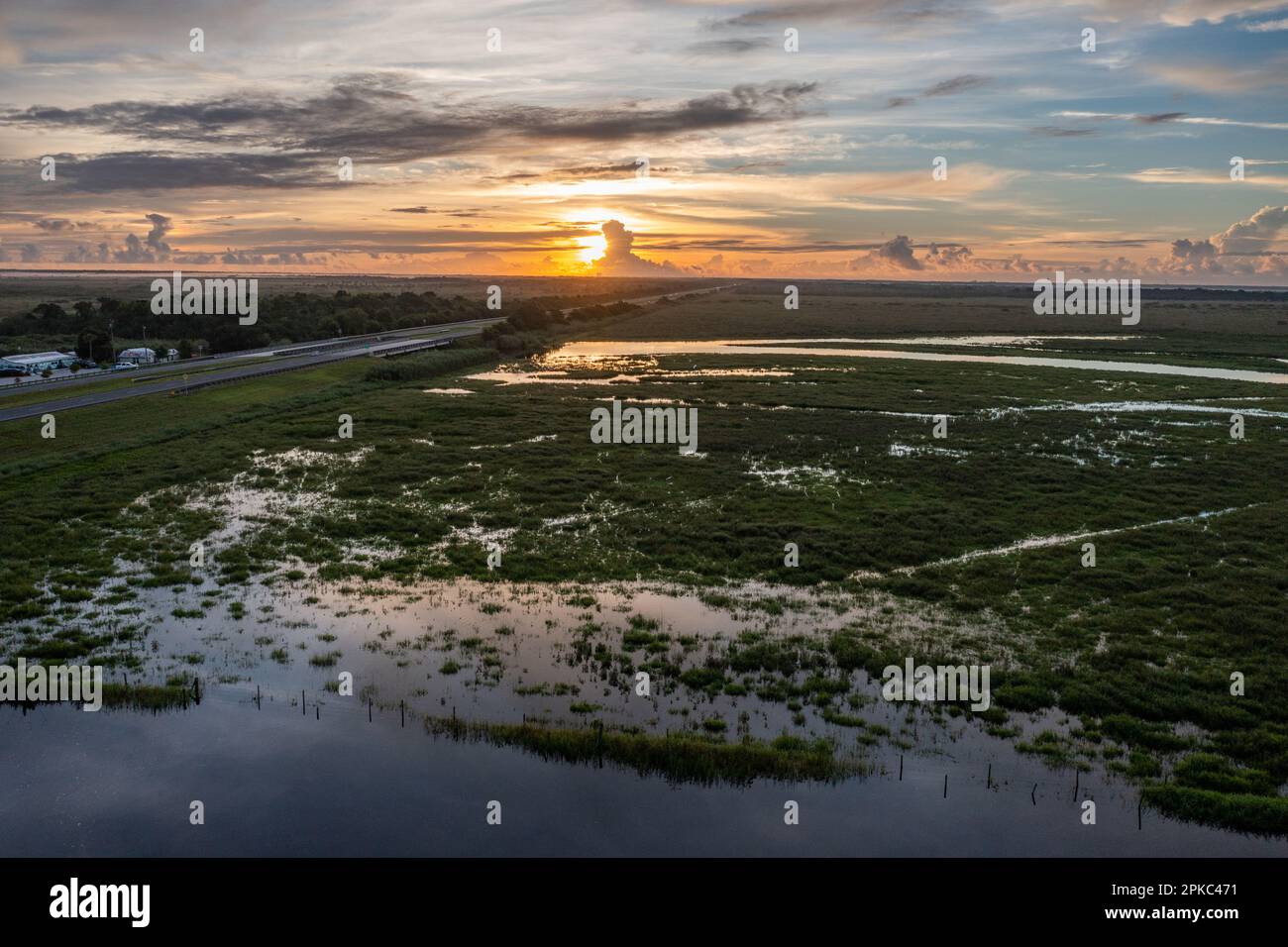 Image aérienne de l'horizon avec un coucher de soleil au-dessus de la zone humide verte en Floride Banque D'Images