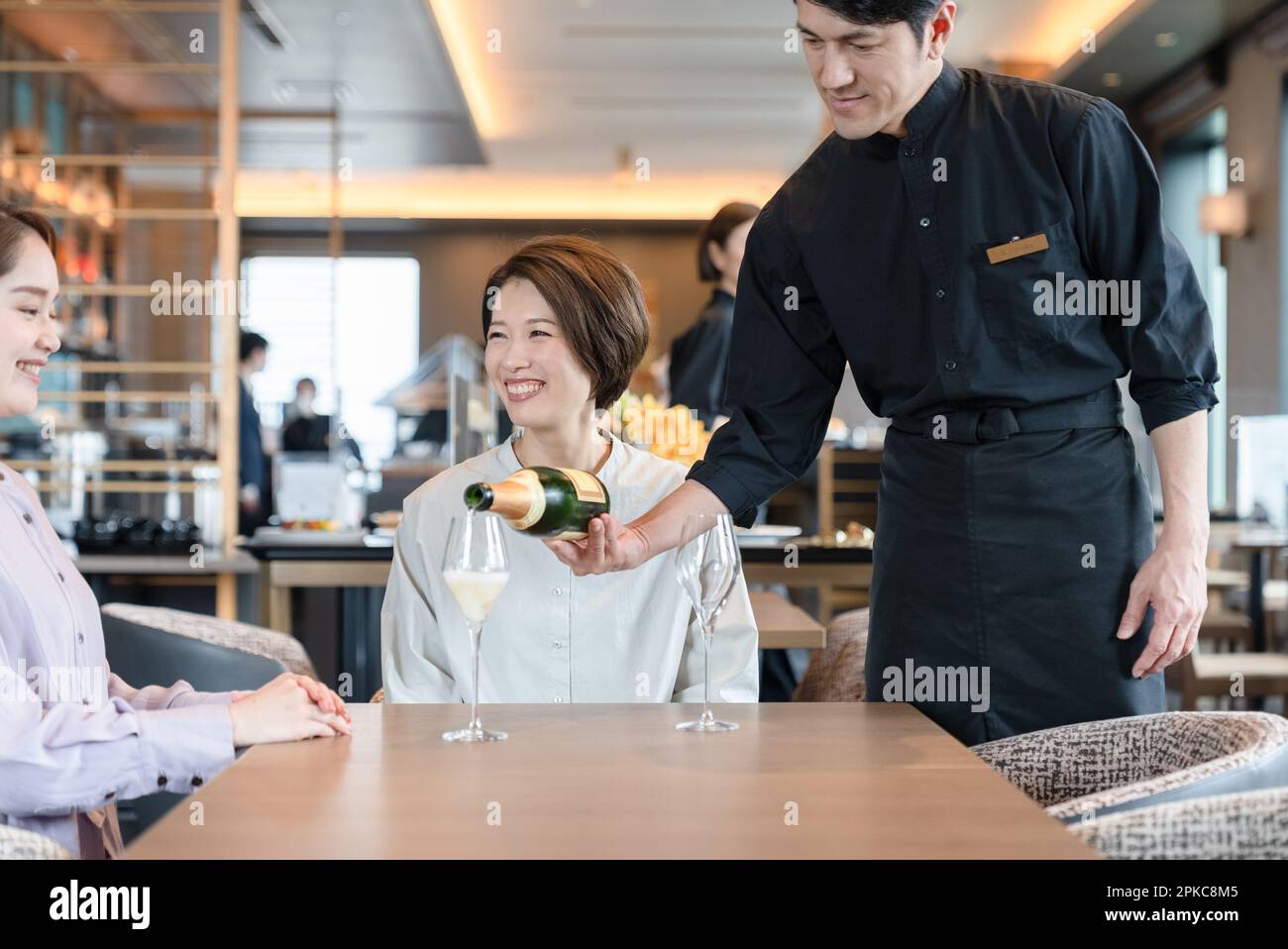 Le personnel du restaurant verse du champagne Banque D'Images