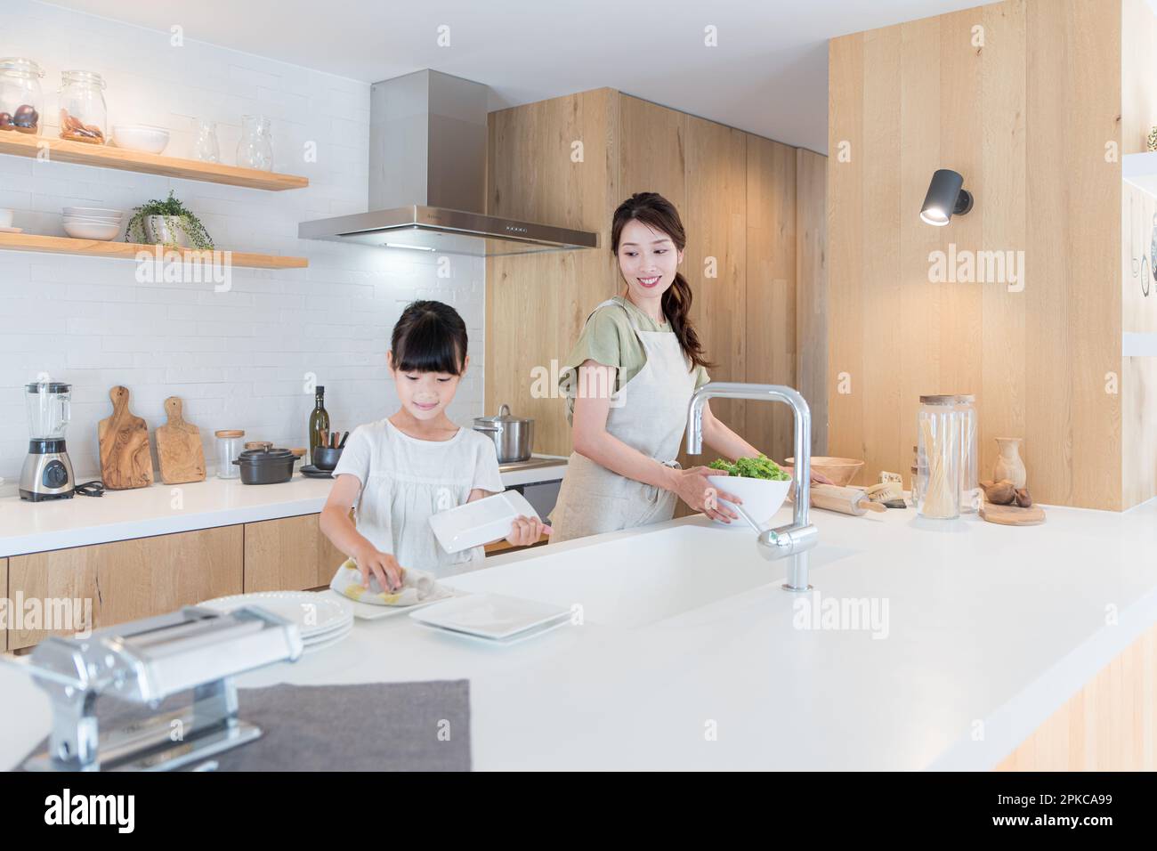 Mère et fille aidant à préparer un repas dans la cuisine Banque D'Images