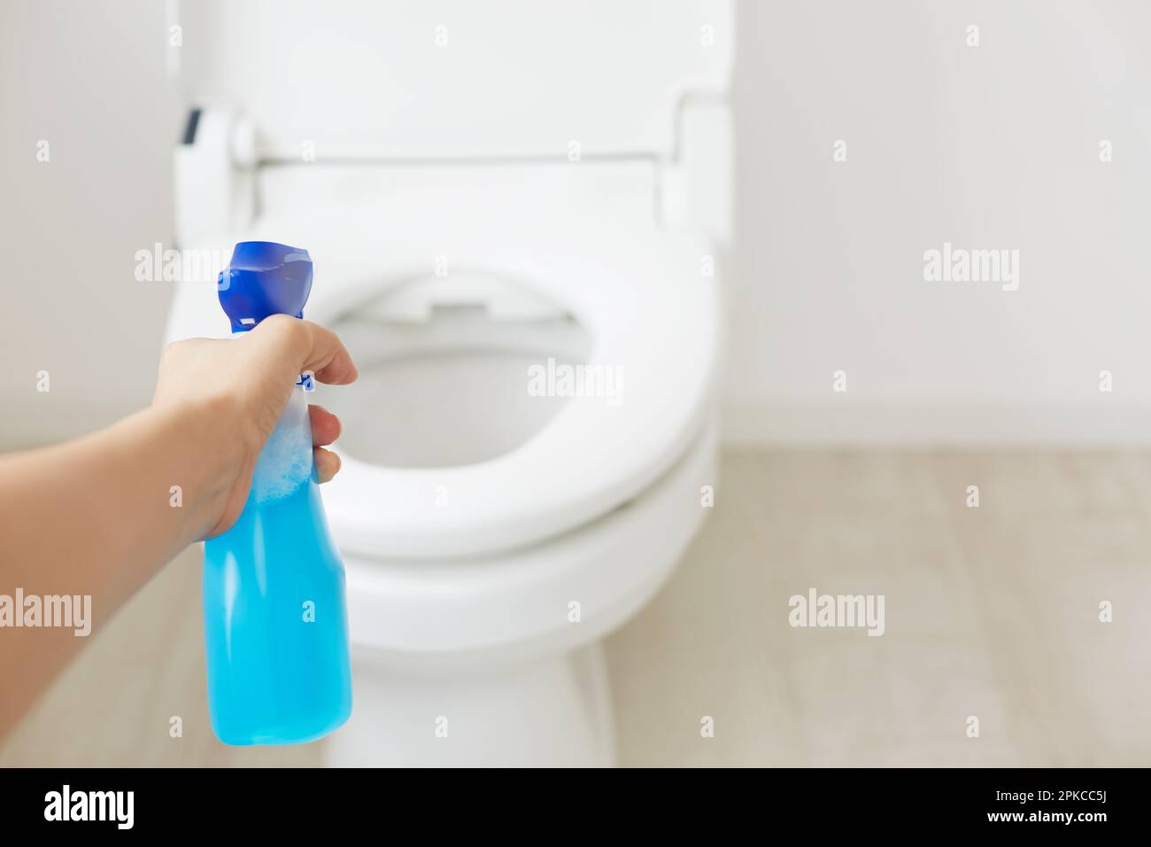 La main de femme pointe le spray vers les toilettes Photo Stock - Alamy