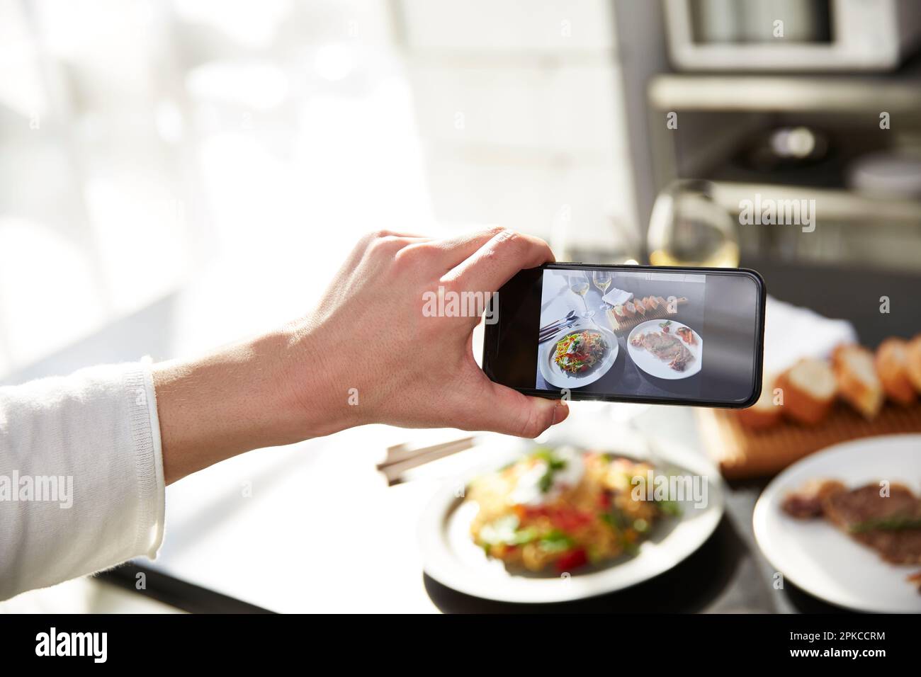 Homme prenant une photo de nourriture avec un appareil photo de téléphone cellulaire Banque D'Images