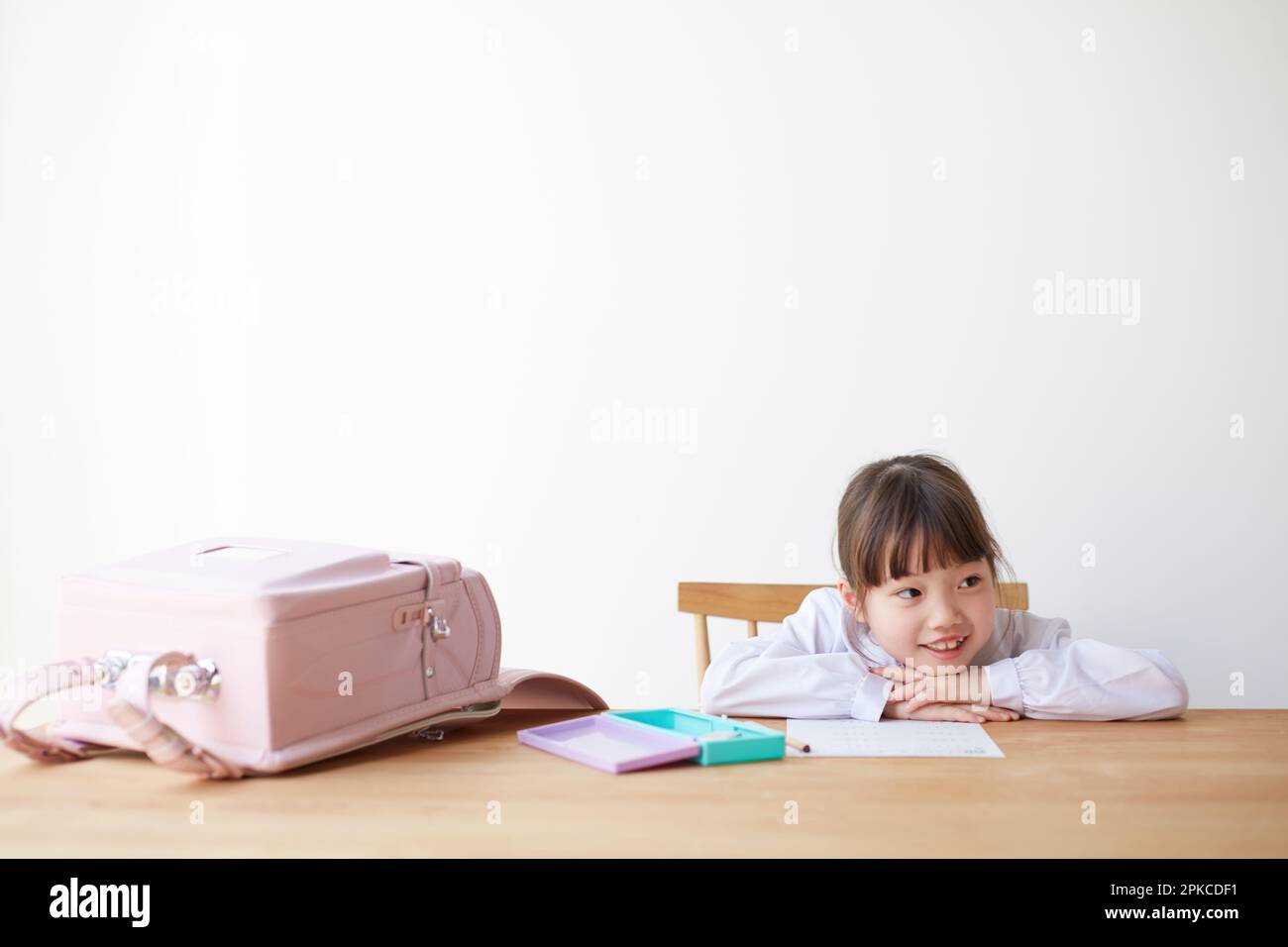 Fille étudiant avec sac d'école étalée sur la table Banque D'Images