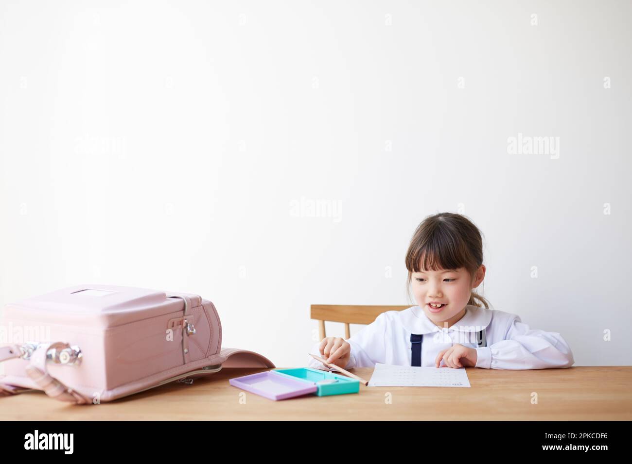 Fille étudiant avec sac d'école étalée sur la table Banque D'Images