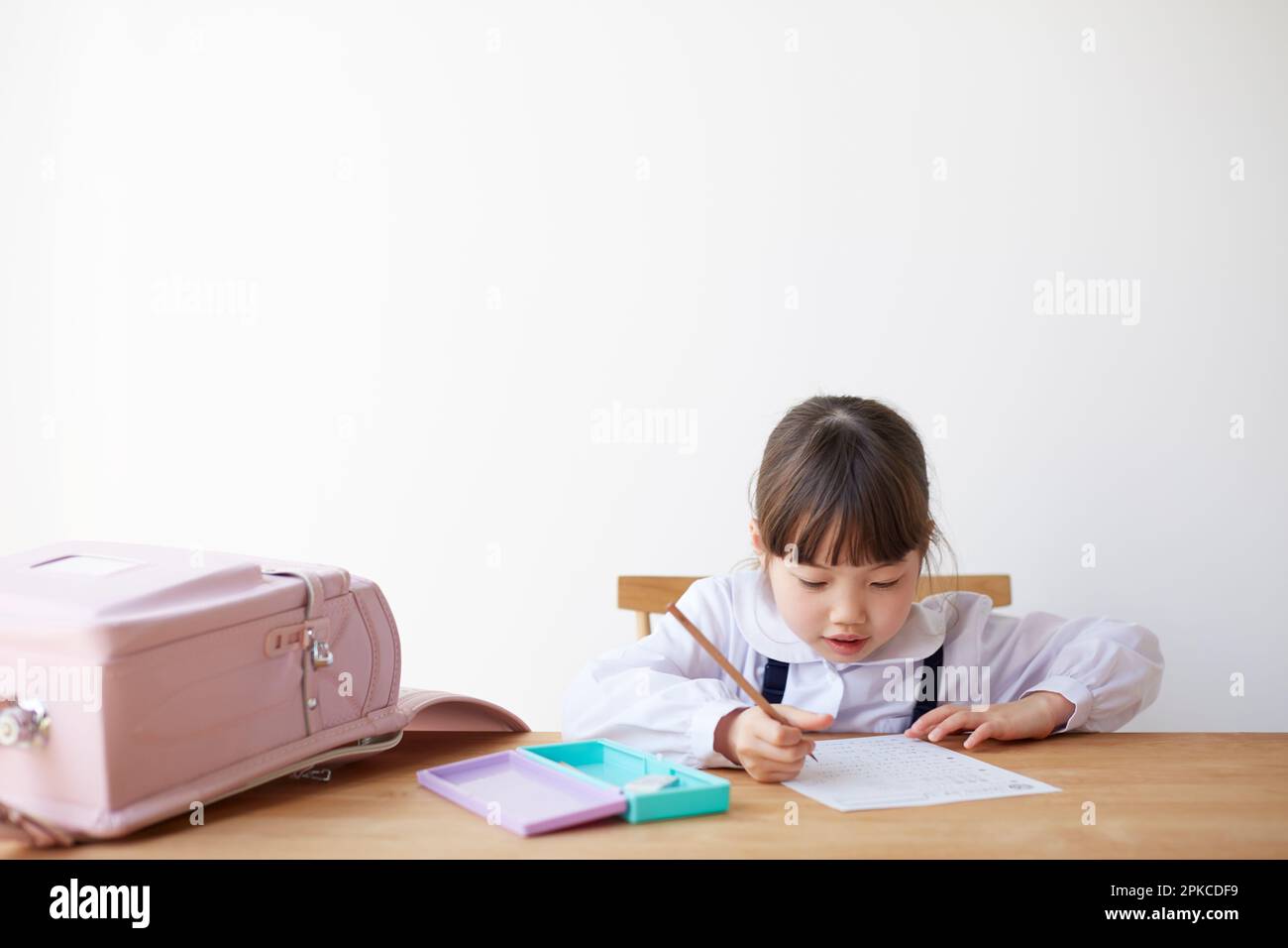 Fille étudiant avec sac d'école étalée sur la table Banque D'Images