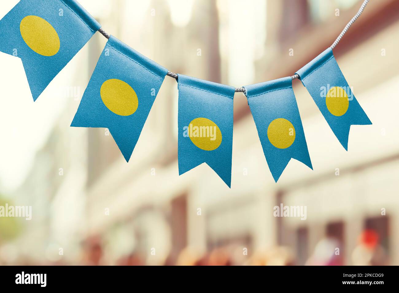 Une guirlande de drapeaux nationaux des Palaos sur un arrière-plan abstrait flou. Banque D'Images