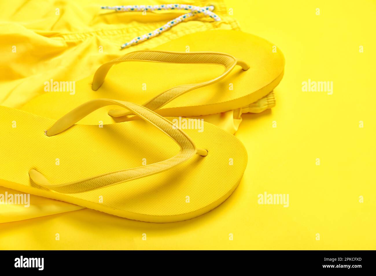 Tongs avec short sur fond jaune, gros plan Photo Stock - Alamy