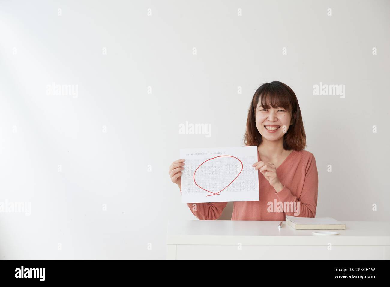 Femme souriante montrant une impression avec un cercle rouge Banque D'Images