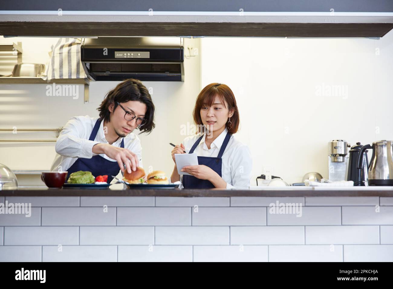 Employé du café prenant des notes tout en étant enseigné par le directeur Banque D'Images