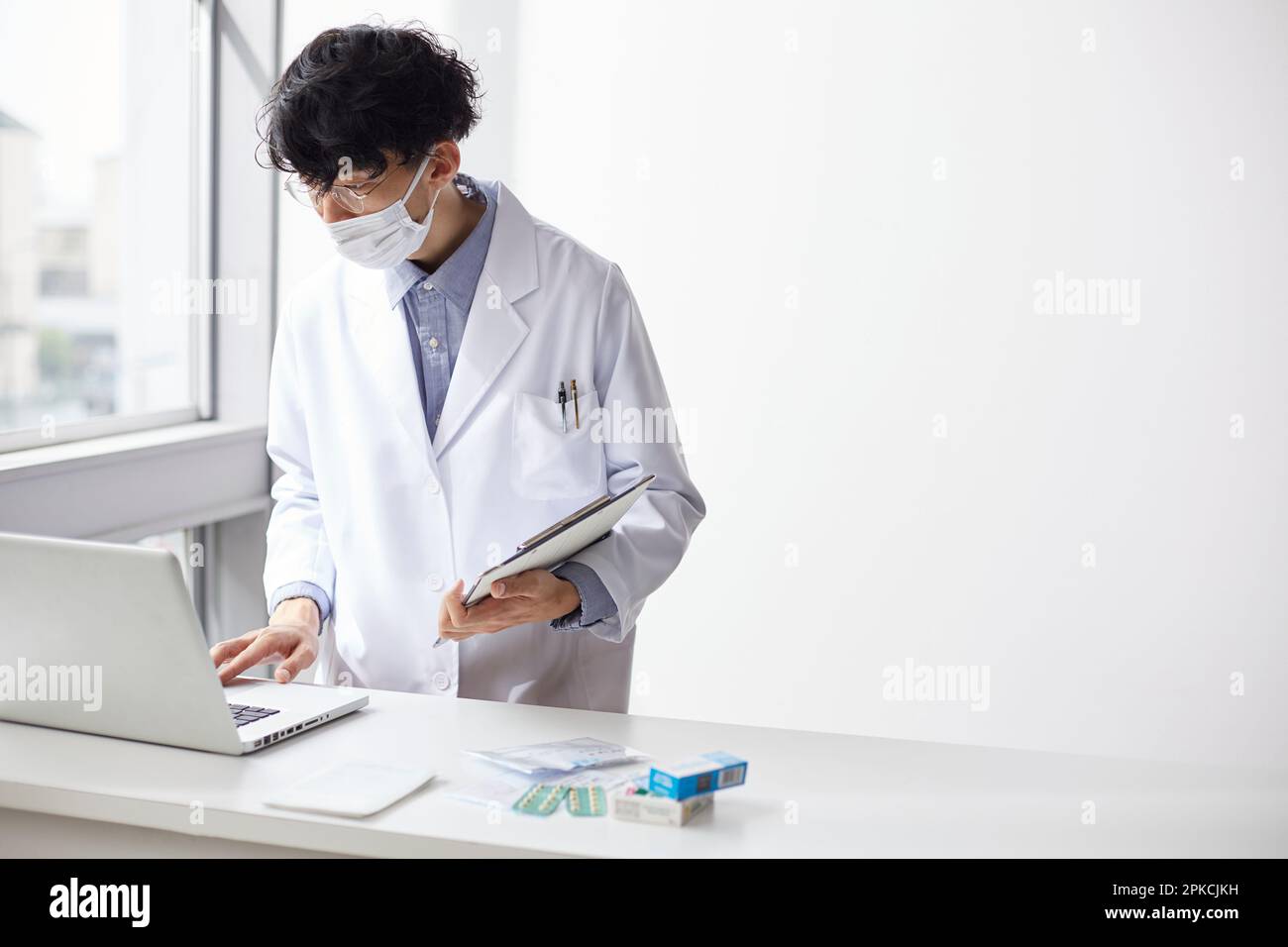 Homme en blanc travaillant à un ordinateur portable sur le comptoir Banque D'Images