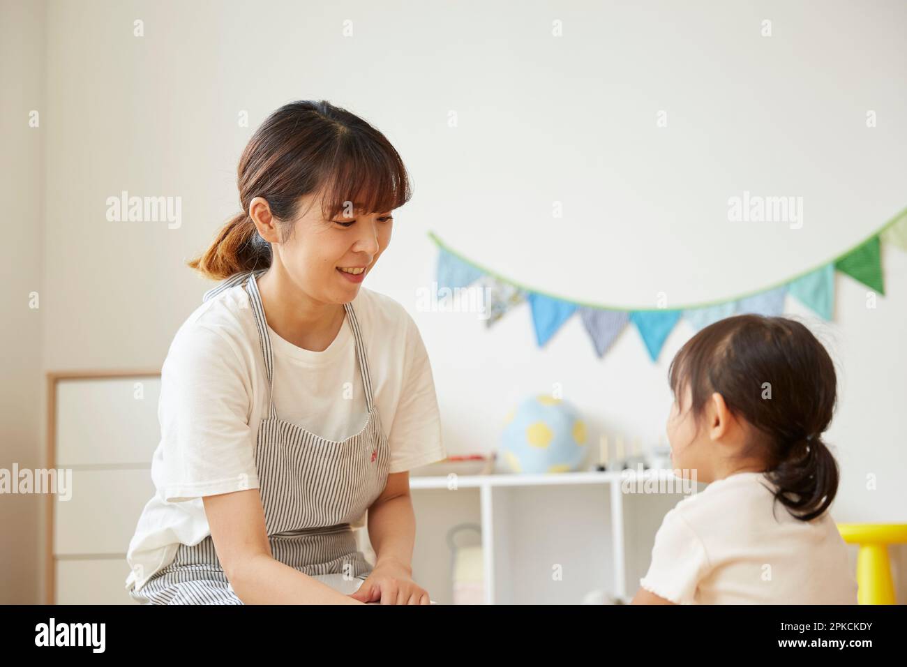 Un préposé à la garde d'enfants s'occupe d'enfants dans une garderie Banque D'Images