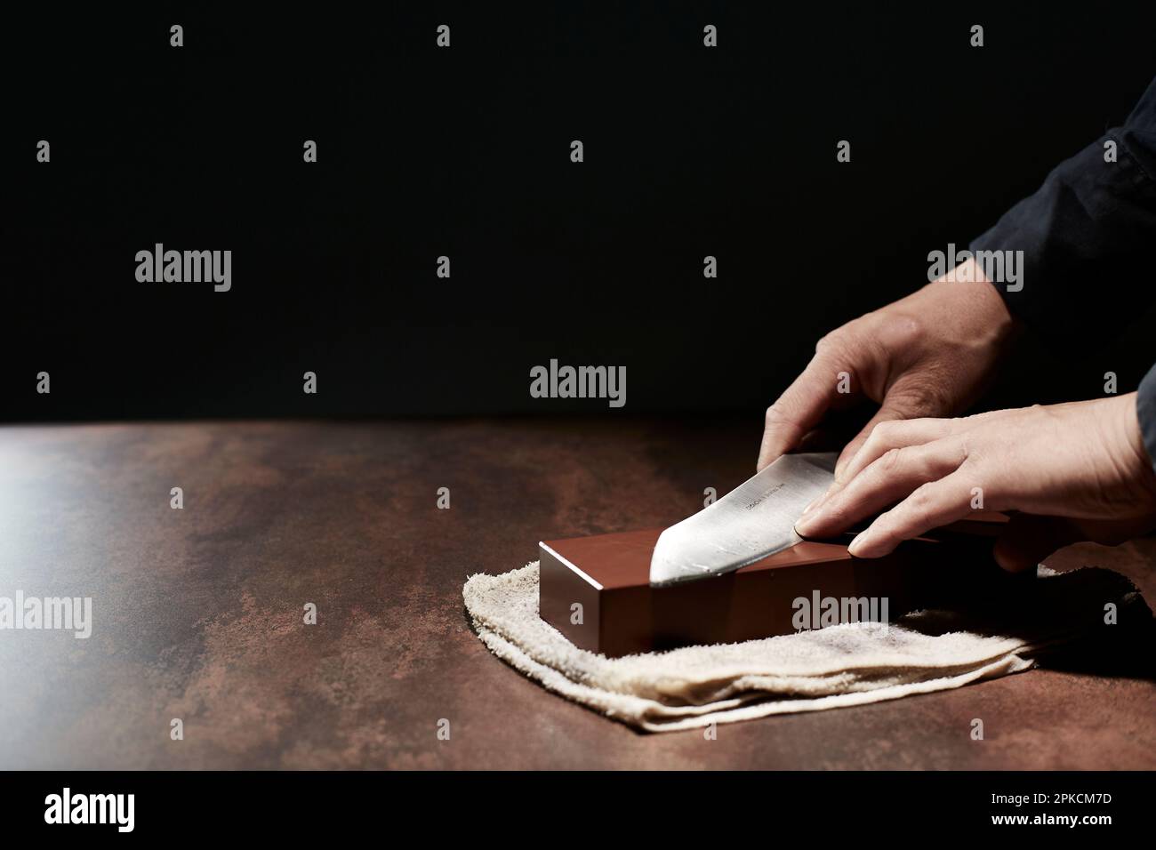 La main de l'homme aiguise un couteau de cuisine Banque D'Images